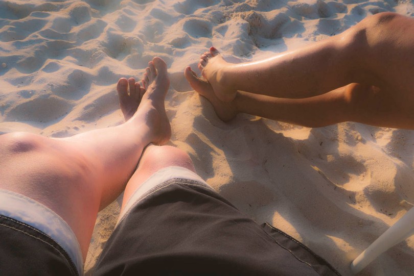 Legs and toes in the sand.
