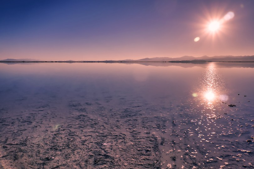The Sun glistens on water covering the Bonneville Salt Flats.